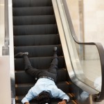 Fallen man at base of an escalator