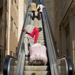 Man pulling bedding up escalator
