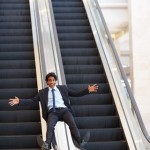 Man sliding down escalator handrail